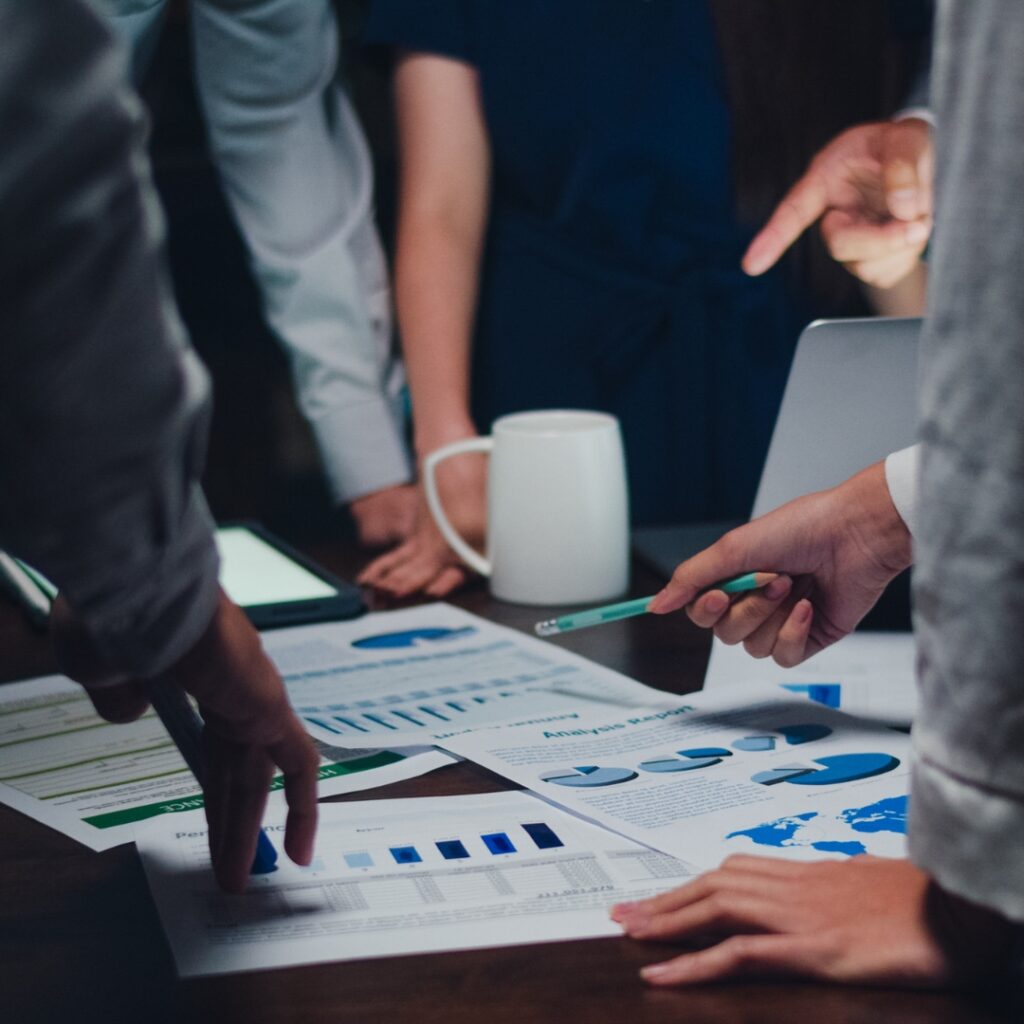 a group of people looking at papers on a table